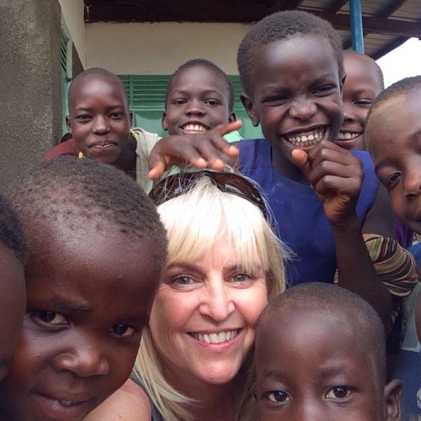 Carole smiling and interacting with a group of children in Uganda