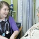 A doctor talks to an elderly woman in hospital.