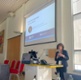 Ciara Rogers is stood at the front of the conference hall addressing attendees.