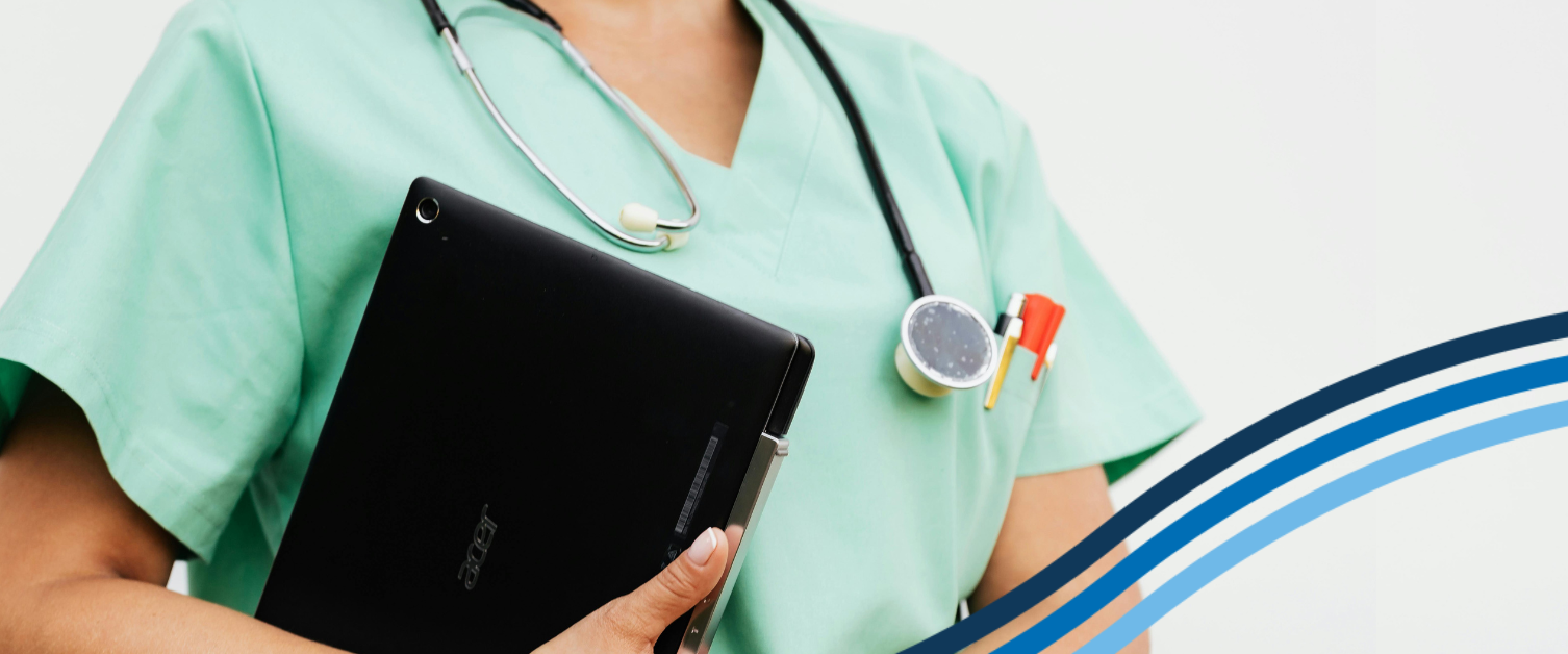 A healthcare professional is holding a laptop.