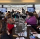 A conference is room is full of people who are listening to a speaker give a presentation.