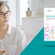 A healthcare professional is having a discussion. She is placed next to the front cover of a document.