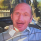 Paul Ridd is smiling. He is wearing a blue jumper.