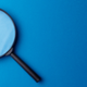 Black Magnifying glass on a blue background