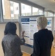 Two people are viewing posters at the conference and pointing at the poster.