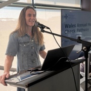 A woman is smiling on a stage.