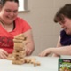 Two people play the game Jenga.