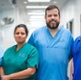 Four clinicians are stood side-by-side in a hospital corridor.