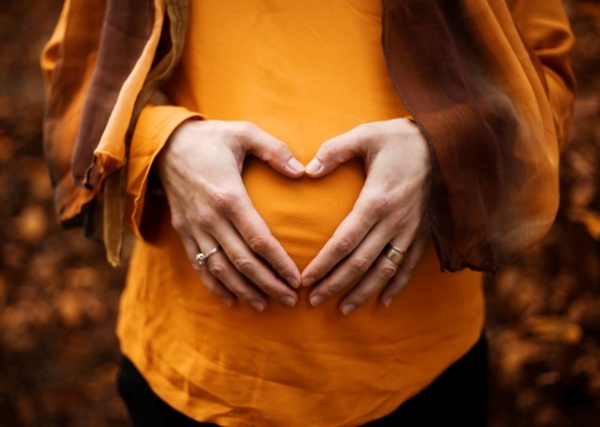 photo of a pregnant lady holding her bump